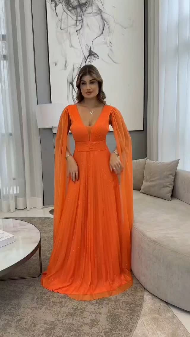 Modelo em vestido laranja com mangas fluidas