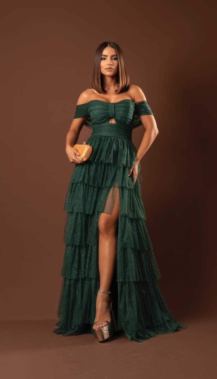 Vista frontal de vestido longo verde-esmeralda em camadas com fenda